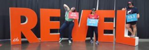 Three runners posing with the REVEL sign